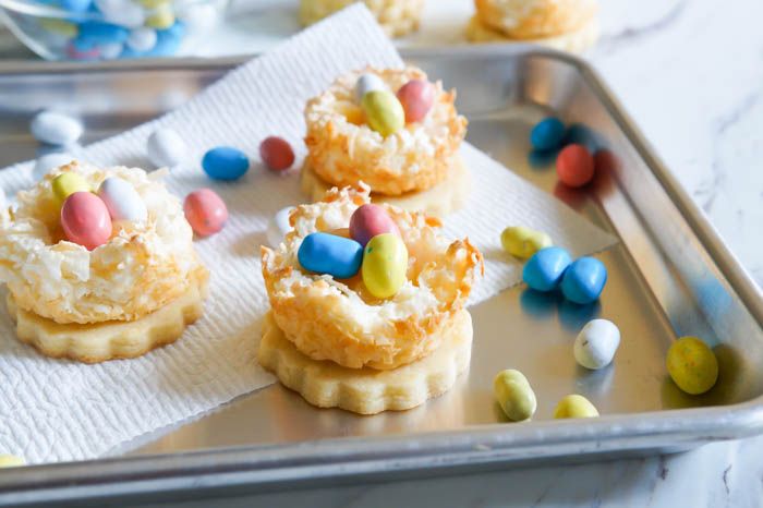 pretty Easter dessert > Lemon Coconut Bird's Nest Cookies...a coconut macaroon nest atop a buttery lemon cookie with lemon curd and chocolate eggs.